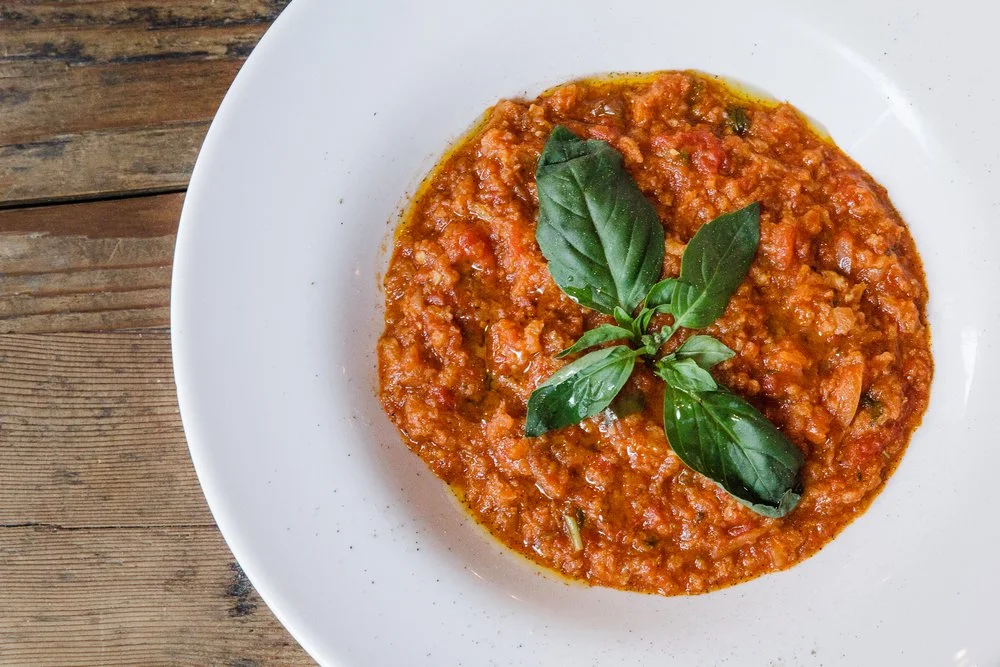 Pappa al pomodoro, Tuscan tomato bread soup, with basil leaves on a white plate
