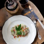 Instagram post: rustic panzanella salad on a white plate on a wooden table