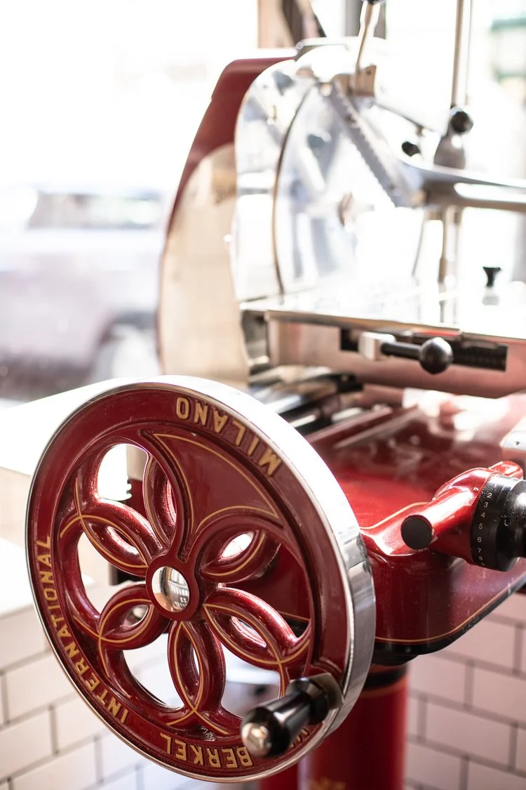 Close-up of a vintage red Berkel Milano manual meat slicer