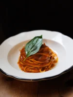 Instagram post: spaghetti in tomato sauce with basil on a white plate
