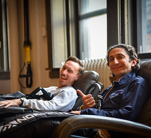 Two athletes relaxing in recovery compression boots