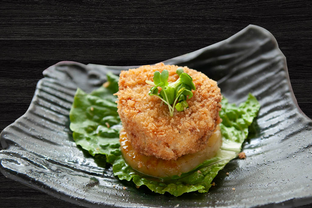 Breaded fried scallop cake on lettuce