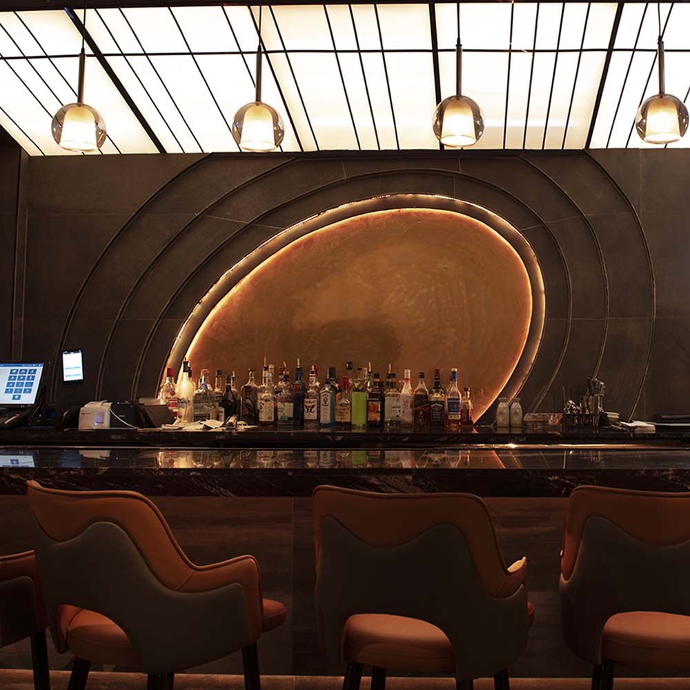 Hane bar interior with curved backlit feature wall and bar stools