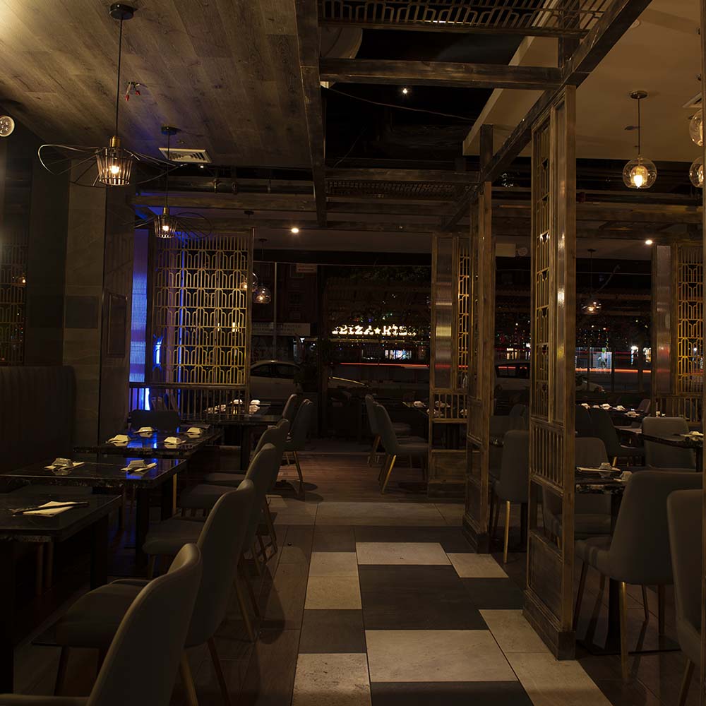 Hane dining room at night with gold lattice partitions and city lights