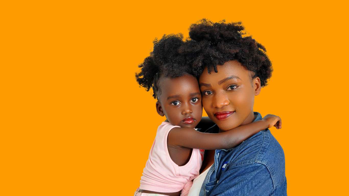 A mother holding her young toddler, both facing the camera against an orange background