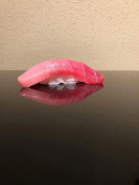 Tuna nigiri on a dark polished surface at Kanoyama