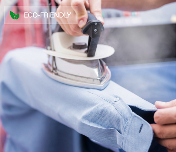 Steam iron pressing a light blue dress shirt, tagged Eco-Friendly