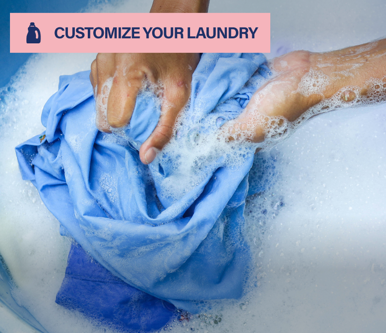 Hands washing blue clothing in soapy water, tagged Customize Your Laundry