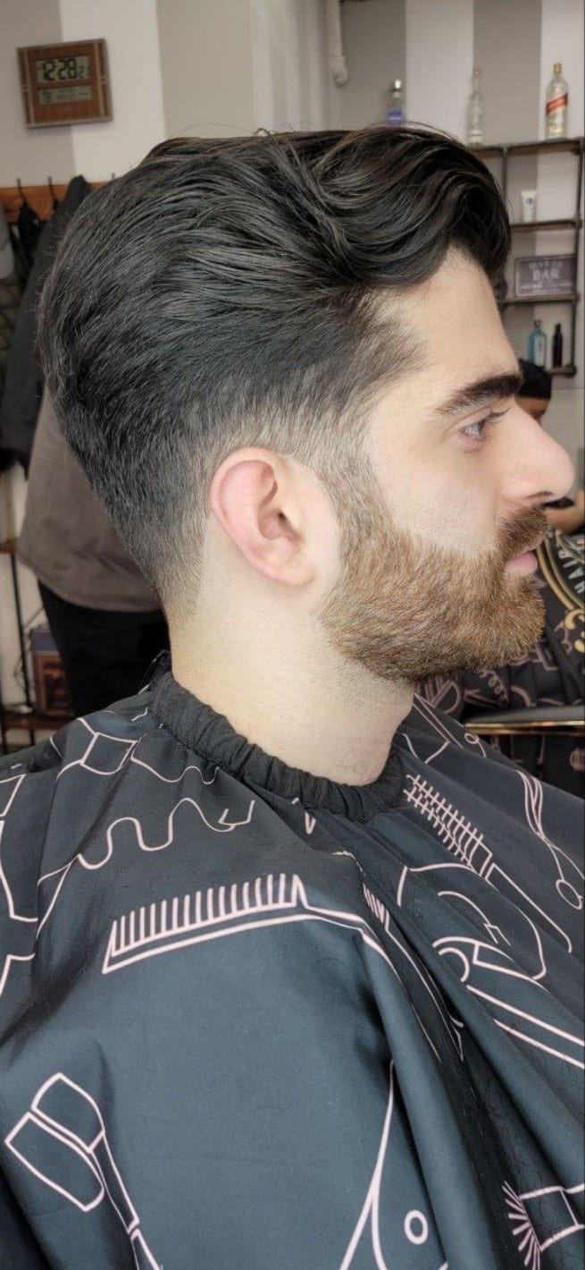 Client with a wavy pompadour fade and beard