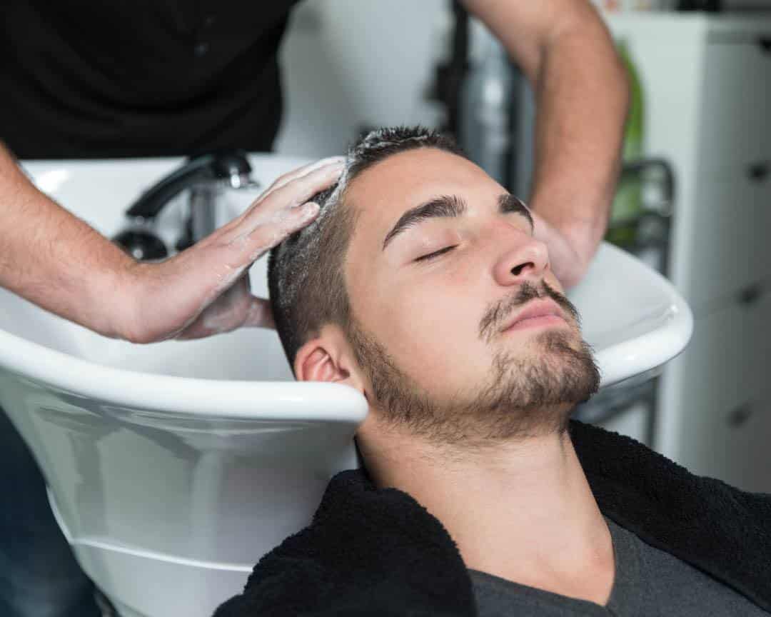 Client having his hair washed at the shampoo bowl