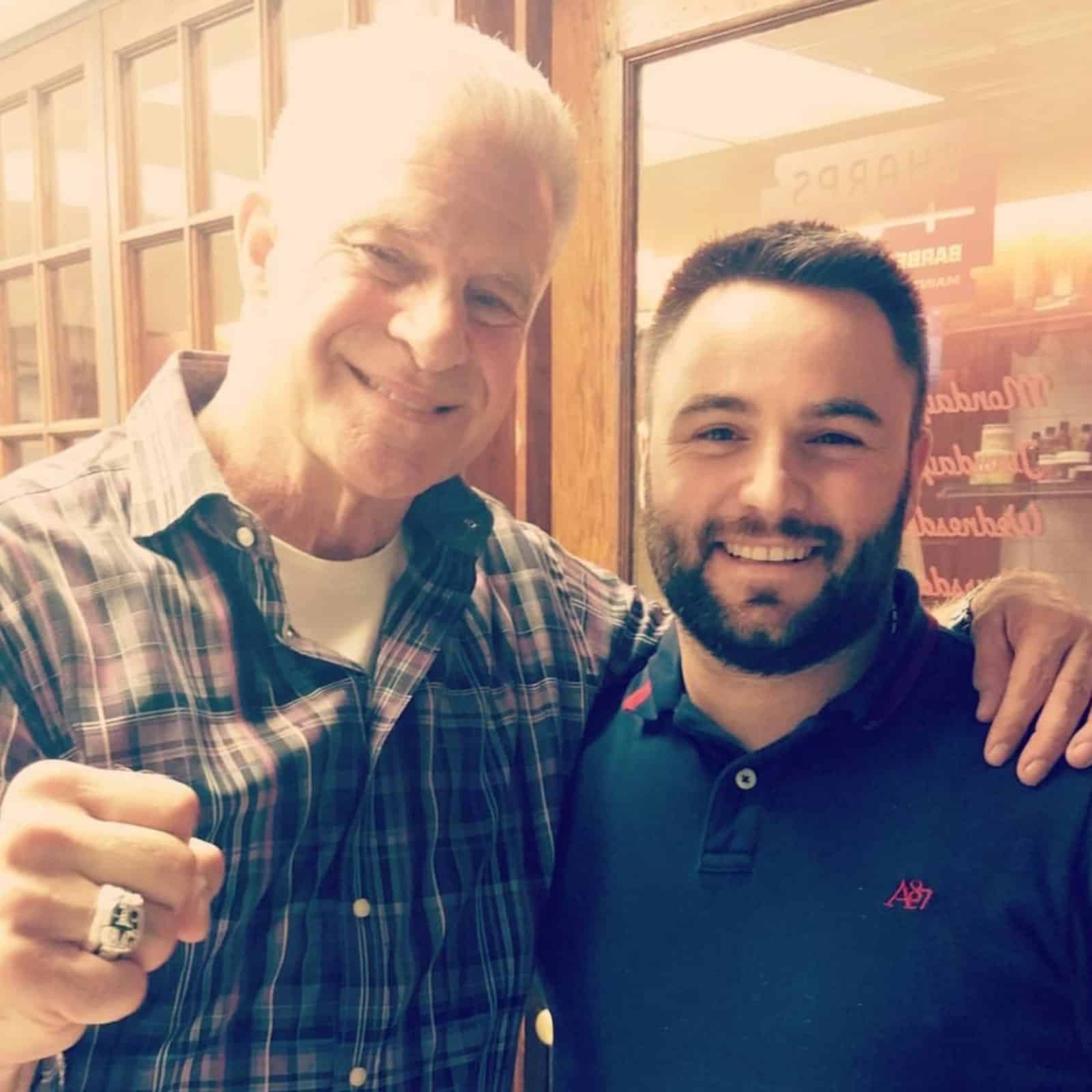 Jim Lampley posing with the barber inside Makas Barbershop