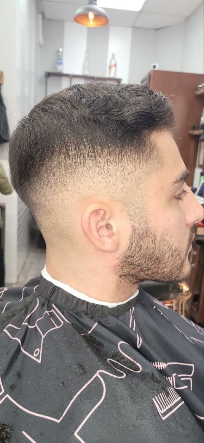 Client profile with a short textured fade and stubble