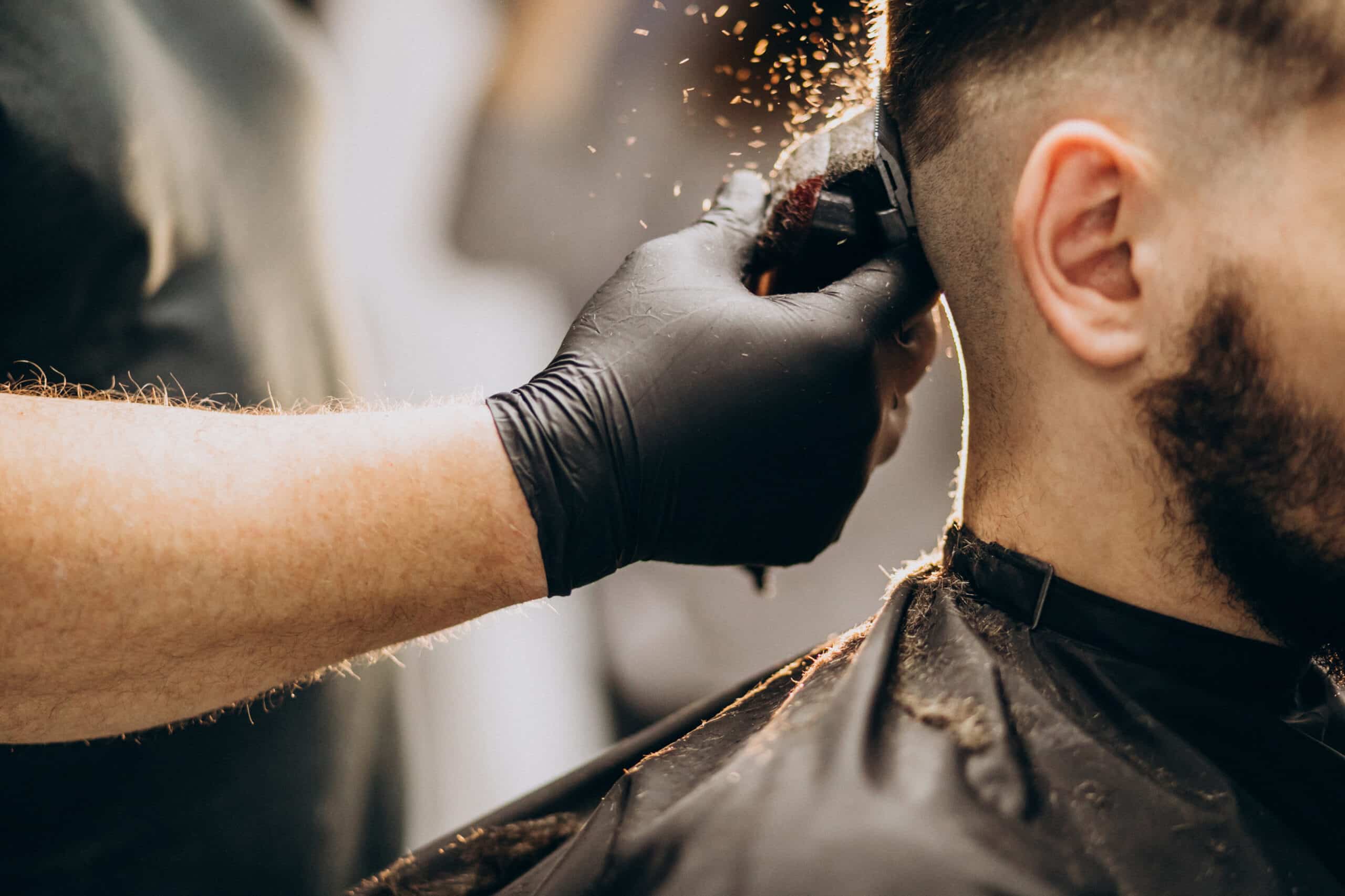 Barber running clippers through a client's hair at Makas Barbershop
