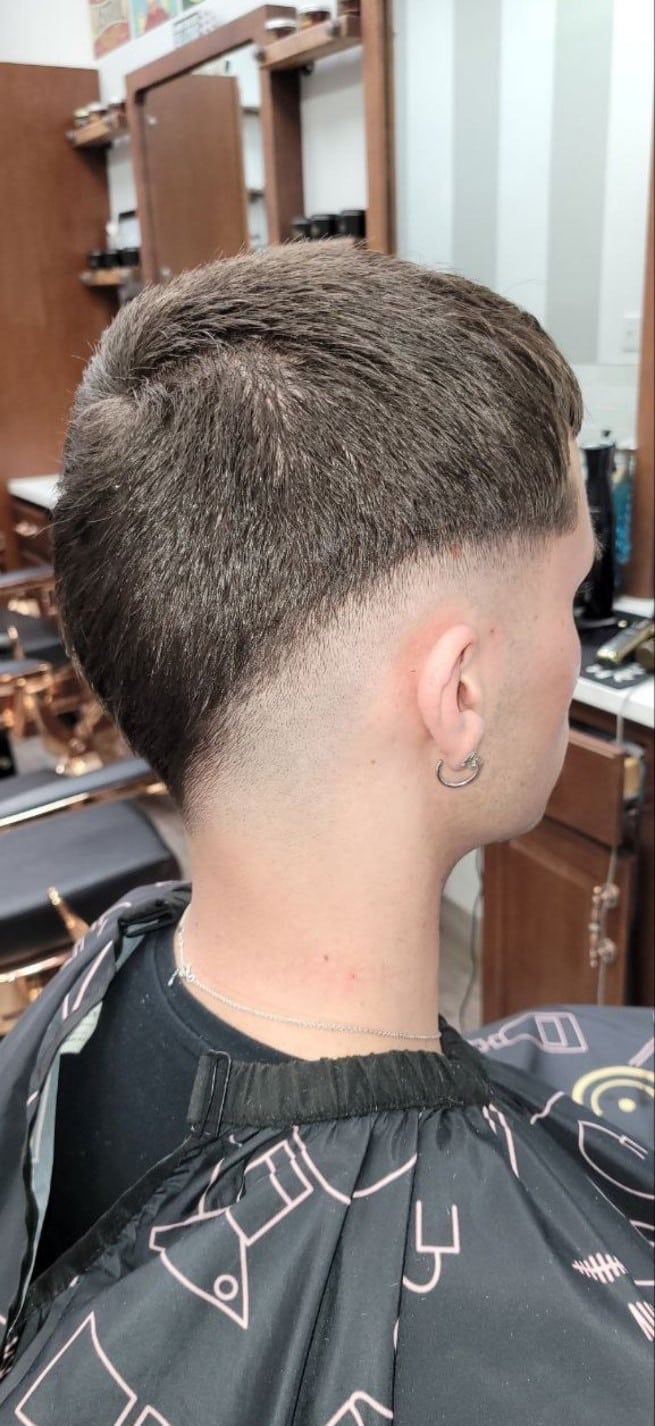 Client rear view with a short textured buzz and skin fade