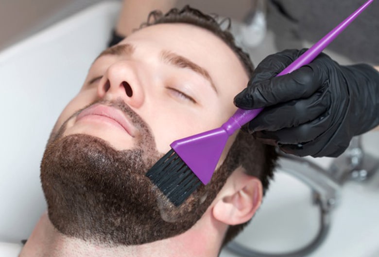 Barber applying beard dye with a brush