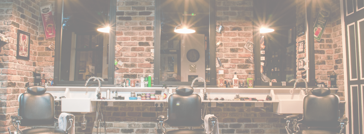 Interior of Makas Barbershop with brick walls, barber chairs and pendant lights