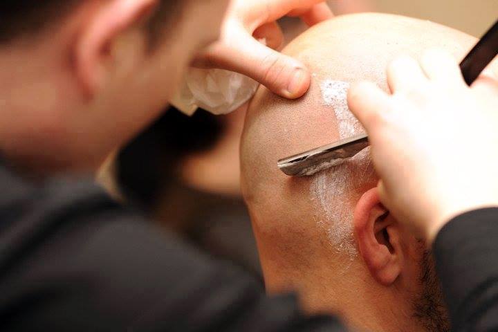 Straight razor shaving a client's head