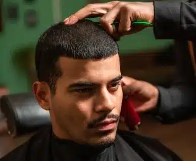Barber combing a client getting a buzz cut