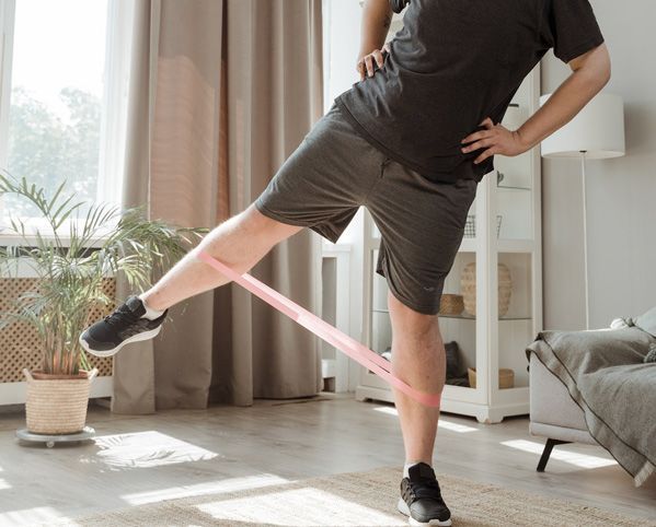 Man exercising at home with a resistance band