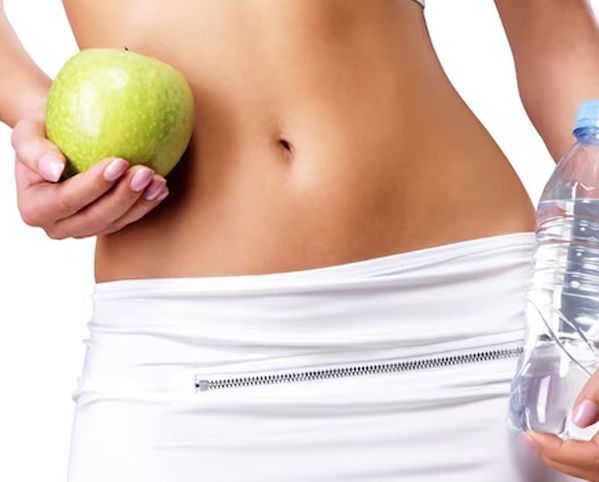 Woman holding a green apple and water bottle, healthy lifestyle concept