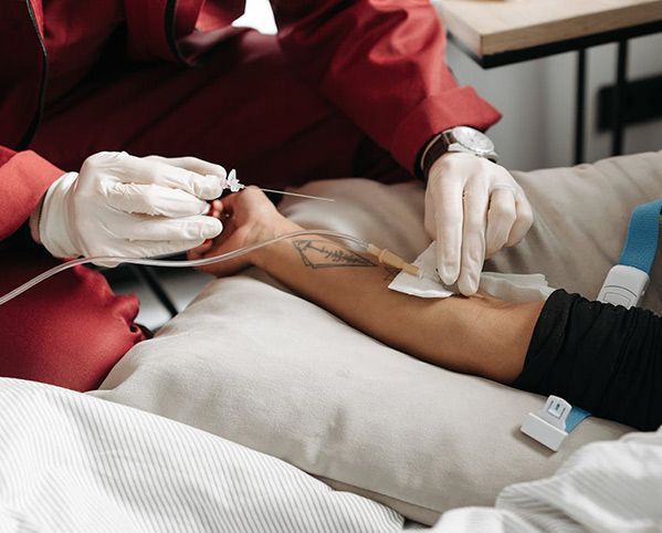 Medical professional inserting an IV catheter into a patient's arm