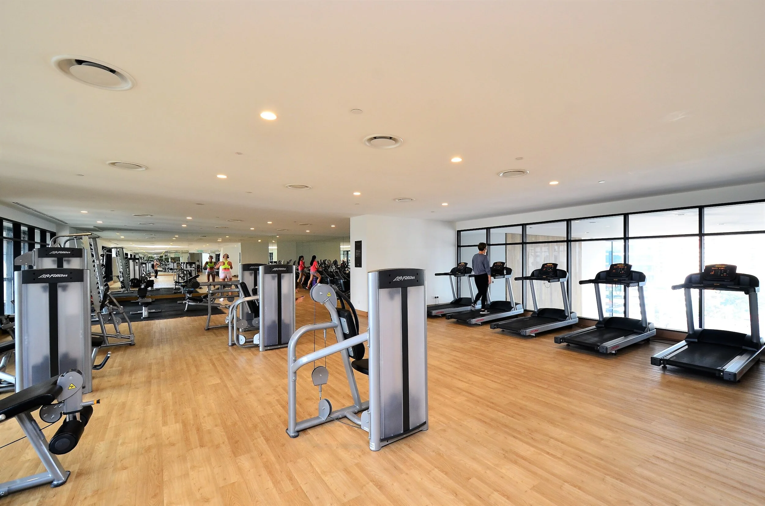 Spacious modern hotel gym interior with treadmills and large windows