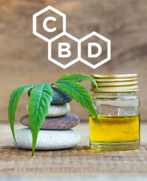 CBD oil bottle with cannabis leaf and stacked stones