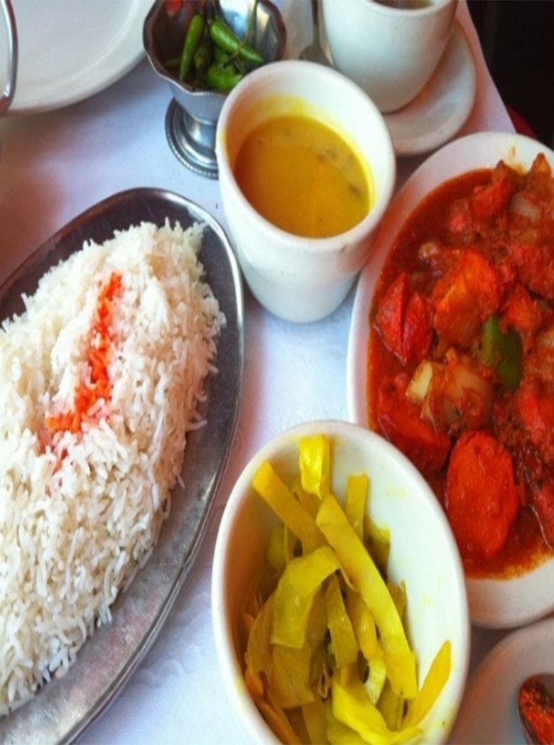 Basmati rice with red curry, yellow pickle and a bowl of dal