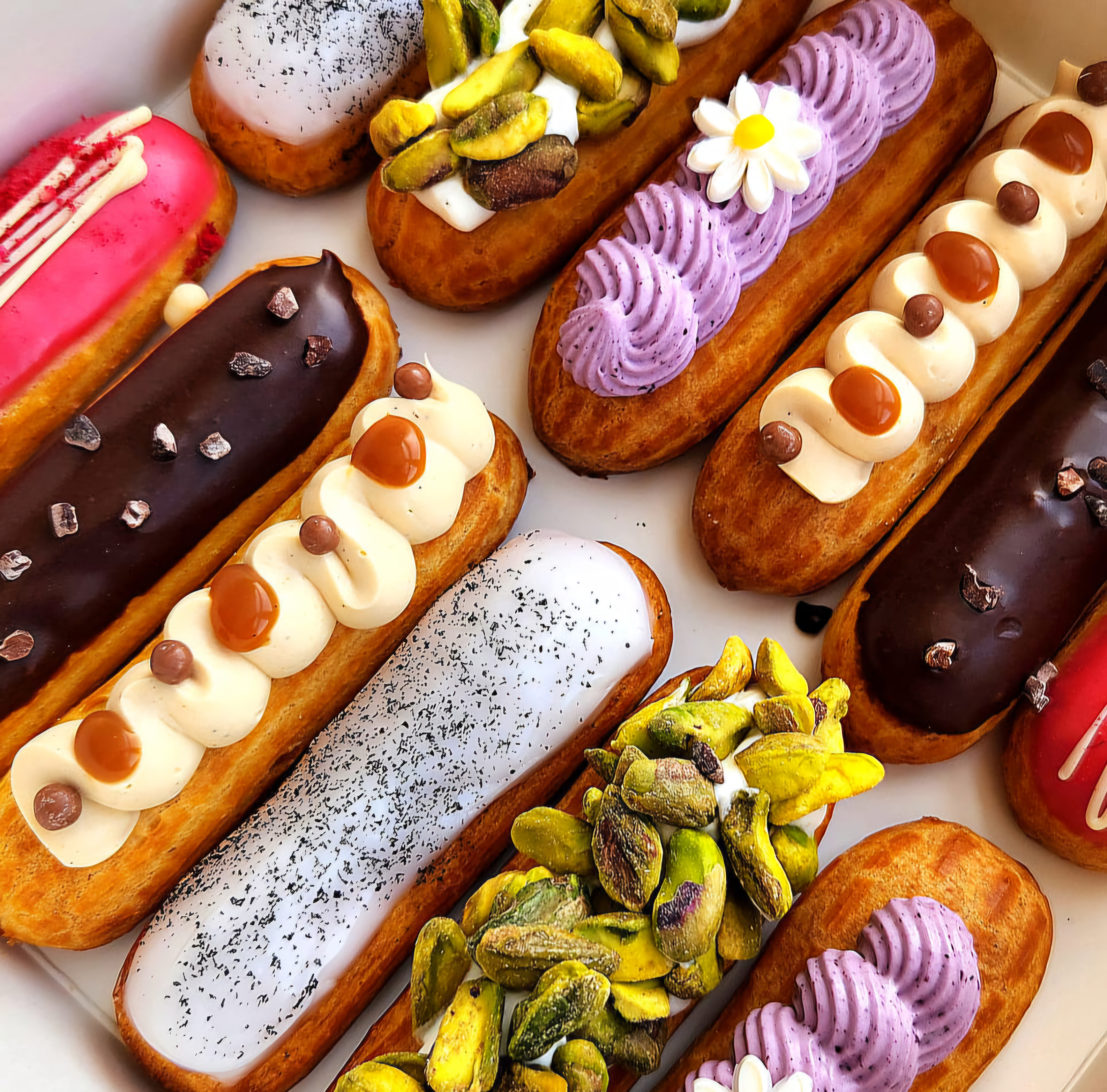 Close crop of chocolate and caramel-topped éclairs