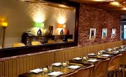 Thumbnail of the Pylos dining room with exposed brick, bar area and set tables