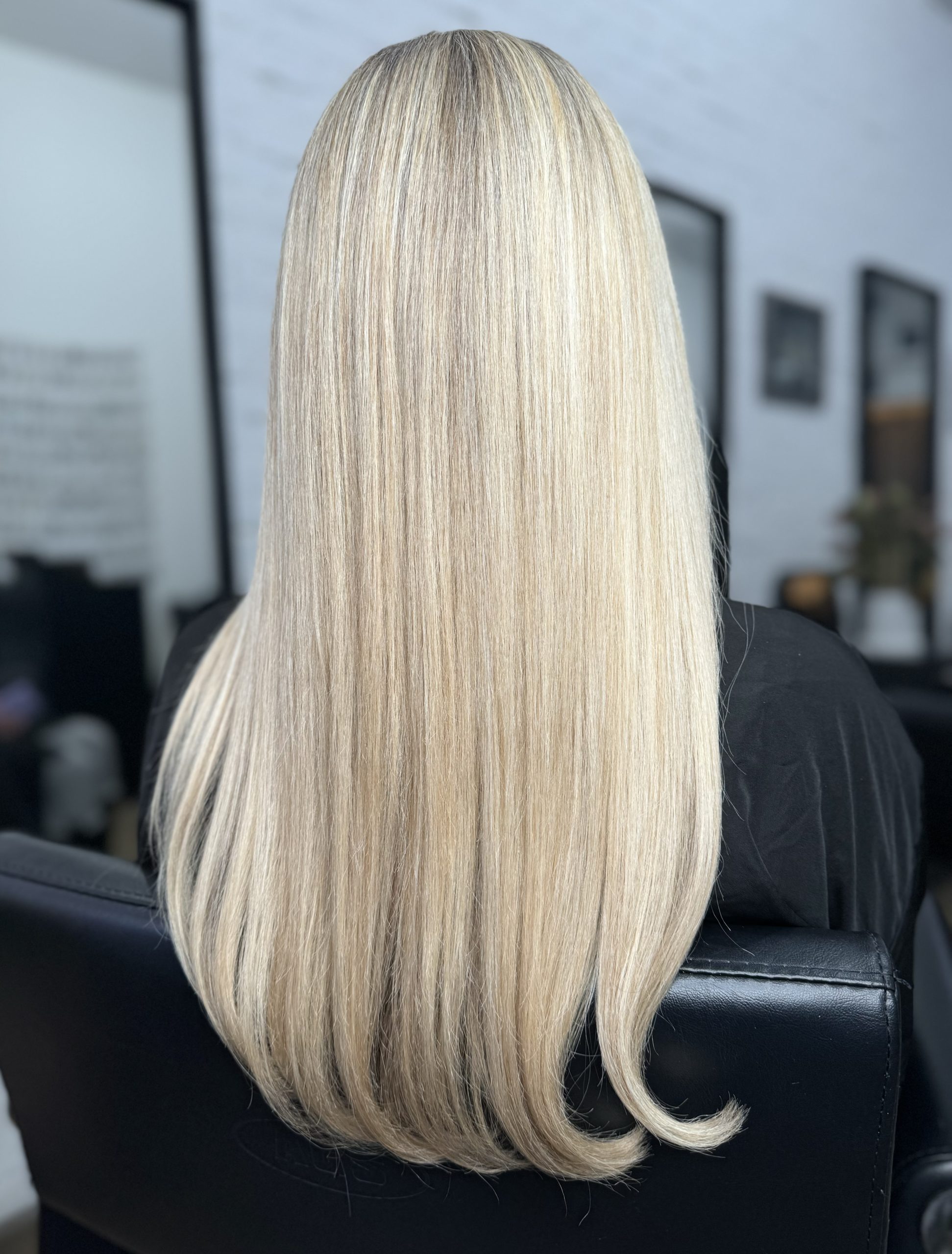 Back view of long straight platinum blonde hair in a salon chair
