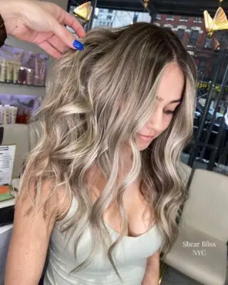 Smiling client with ash blonde balayage waves