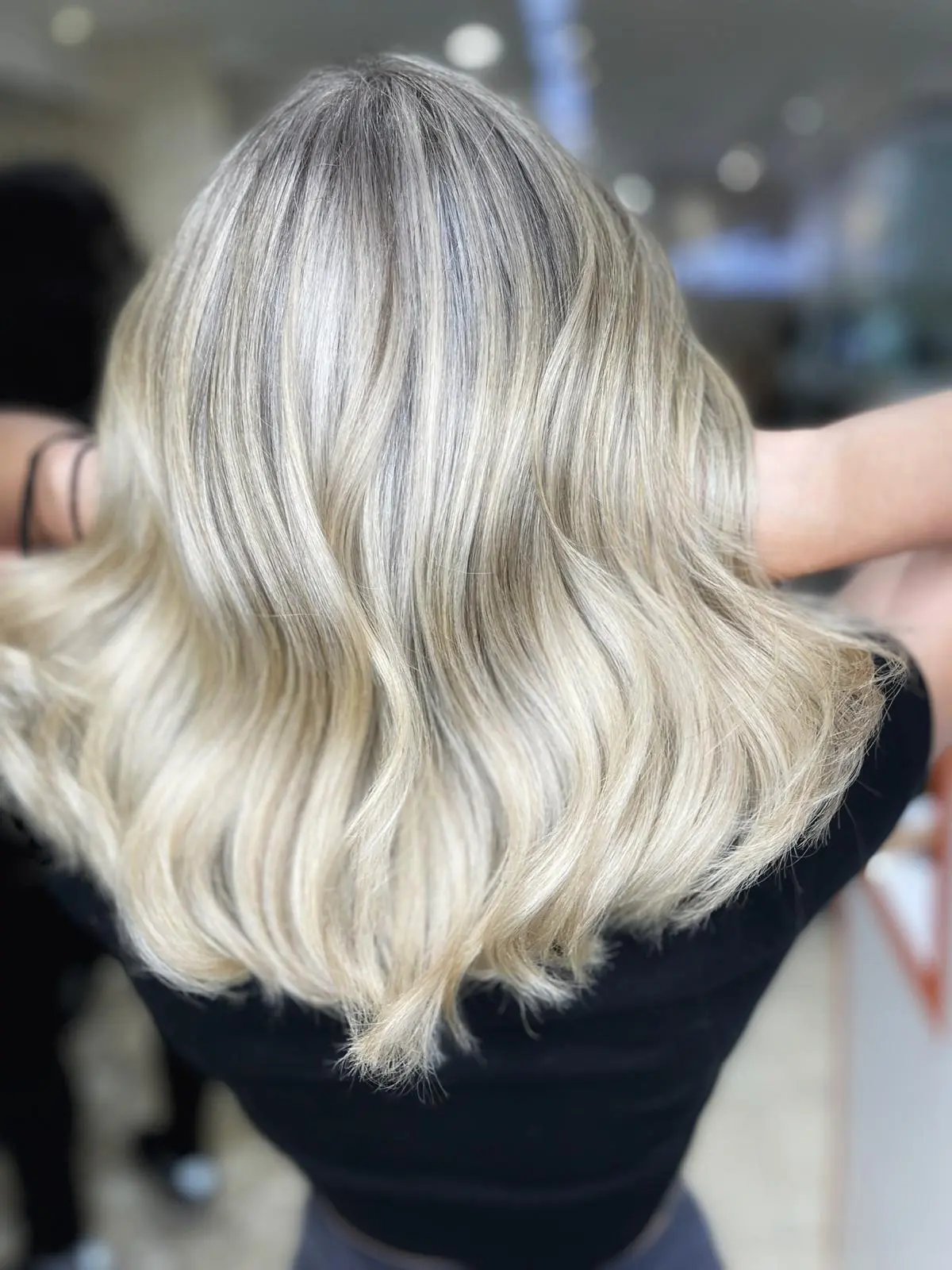 Back view of bright blonde wavy hair in the salon