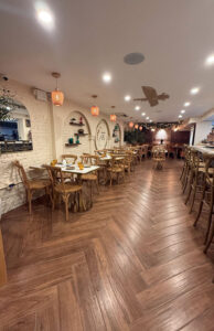 Taftoon's main dining room with herringbone wood floors, arched niches and warm pendant lighting