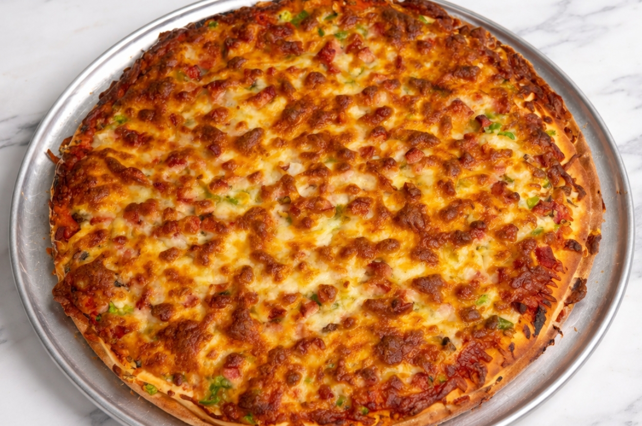 Taftoon Pizza — whole baked pizza with meat sauce and melted cheese on a metal tray