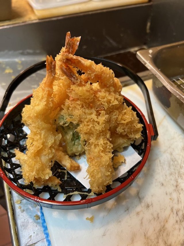 Shrimp and vegetable tempura in a red-rimmed basket
