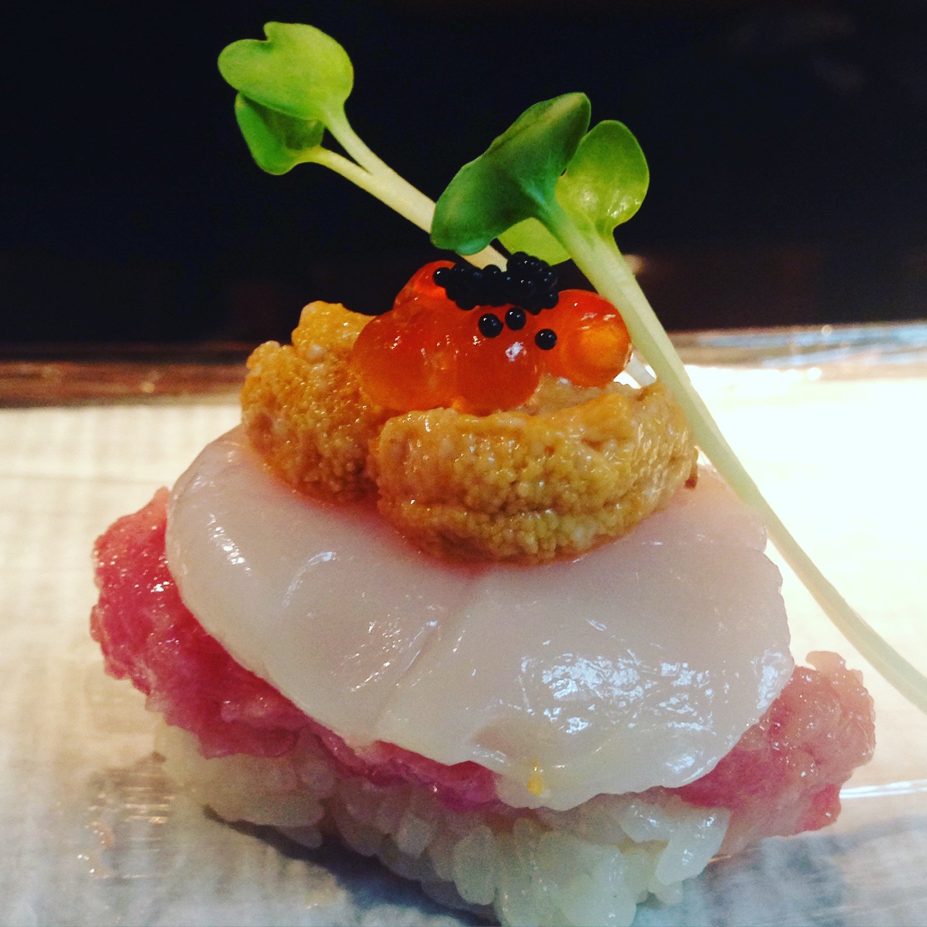 Layered nigiri with uni, ikura, scallop and microgreens