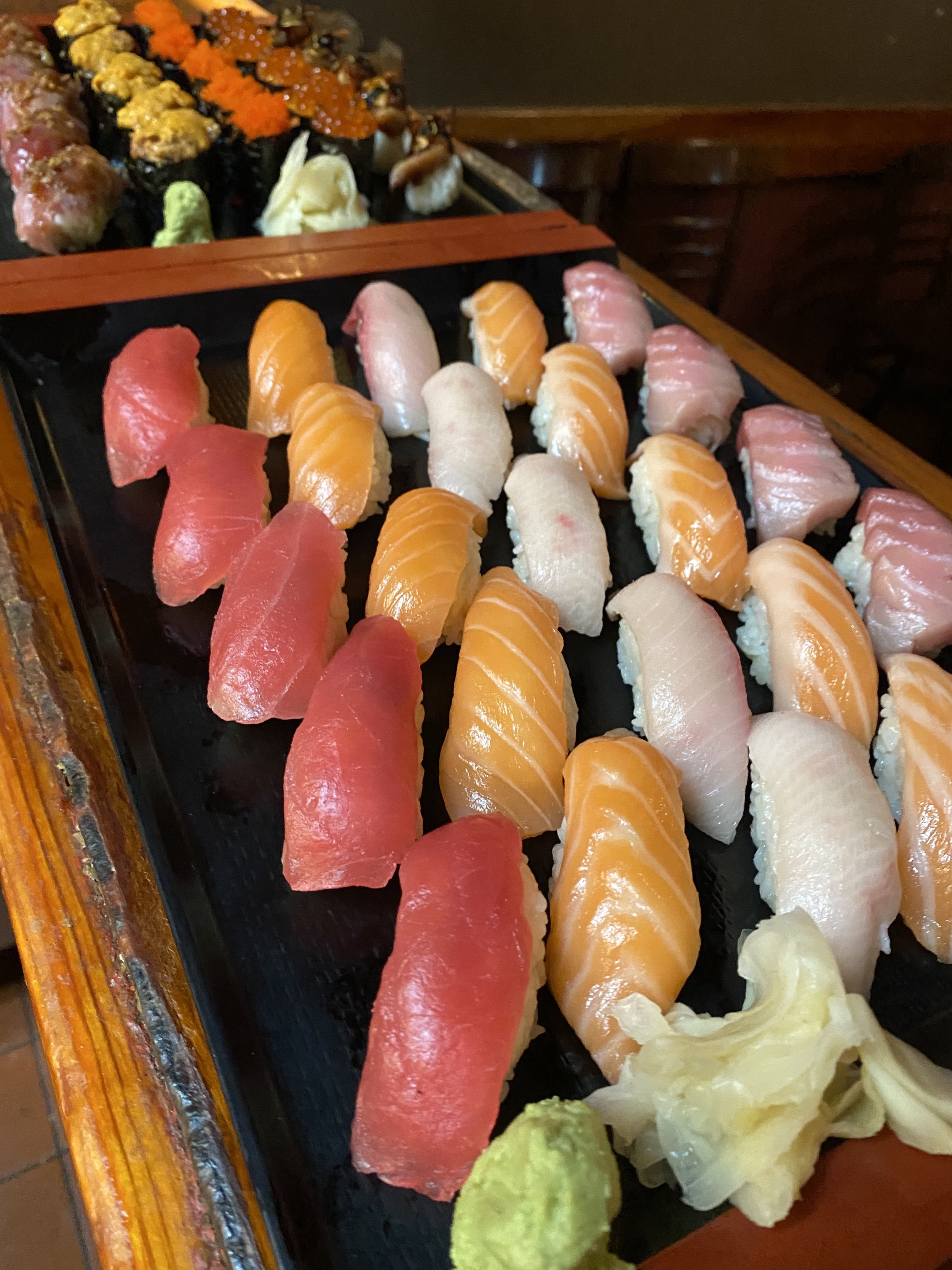 Nigiri spread on black slate with wasabi and ginger