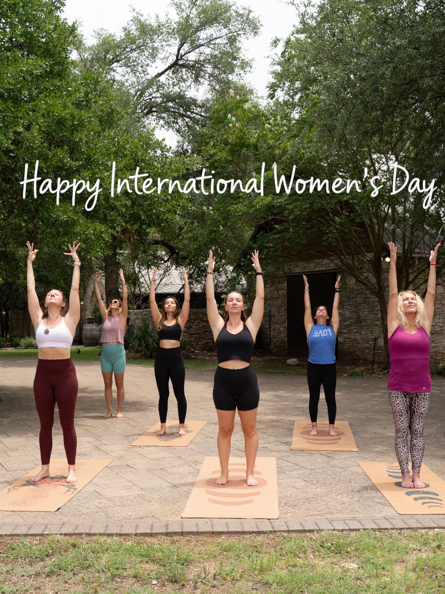 Group outdoor yoga with Happy International Women's Day overlay