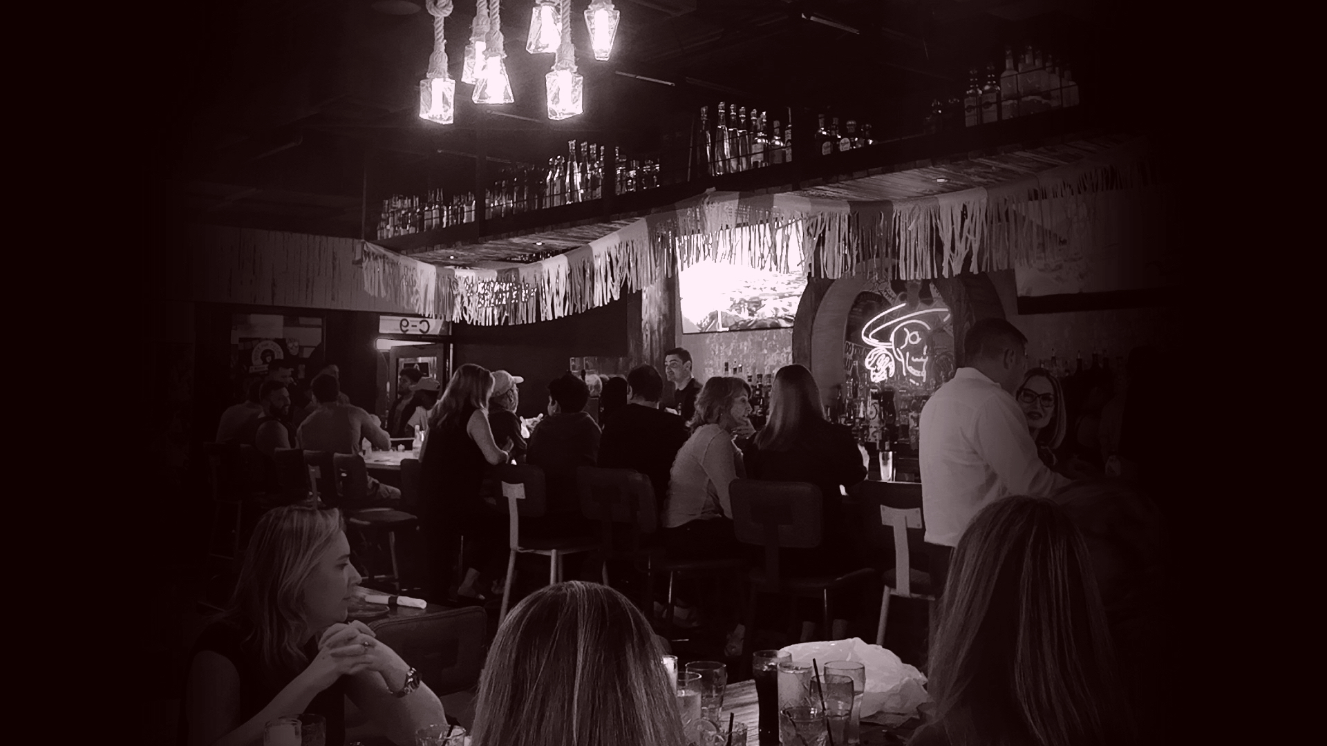 Vote for Pedro cantina bar interior full of guests, bottles and neon