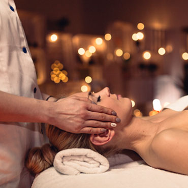 Therapist performing a gentle craniosacral head and face treatment