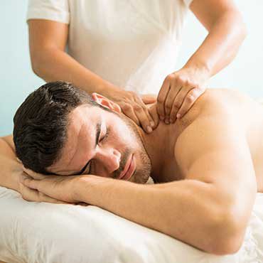 Therapist performing upper back and neck massage on a patient