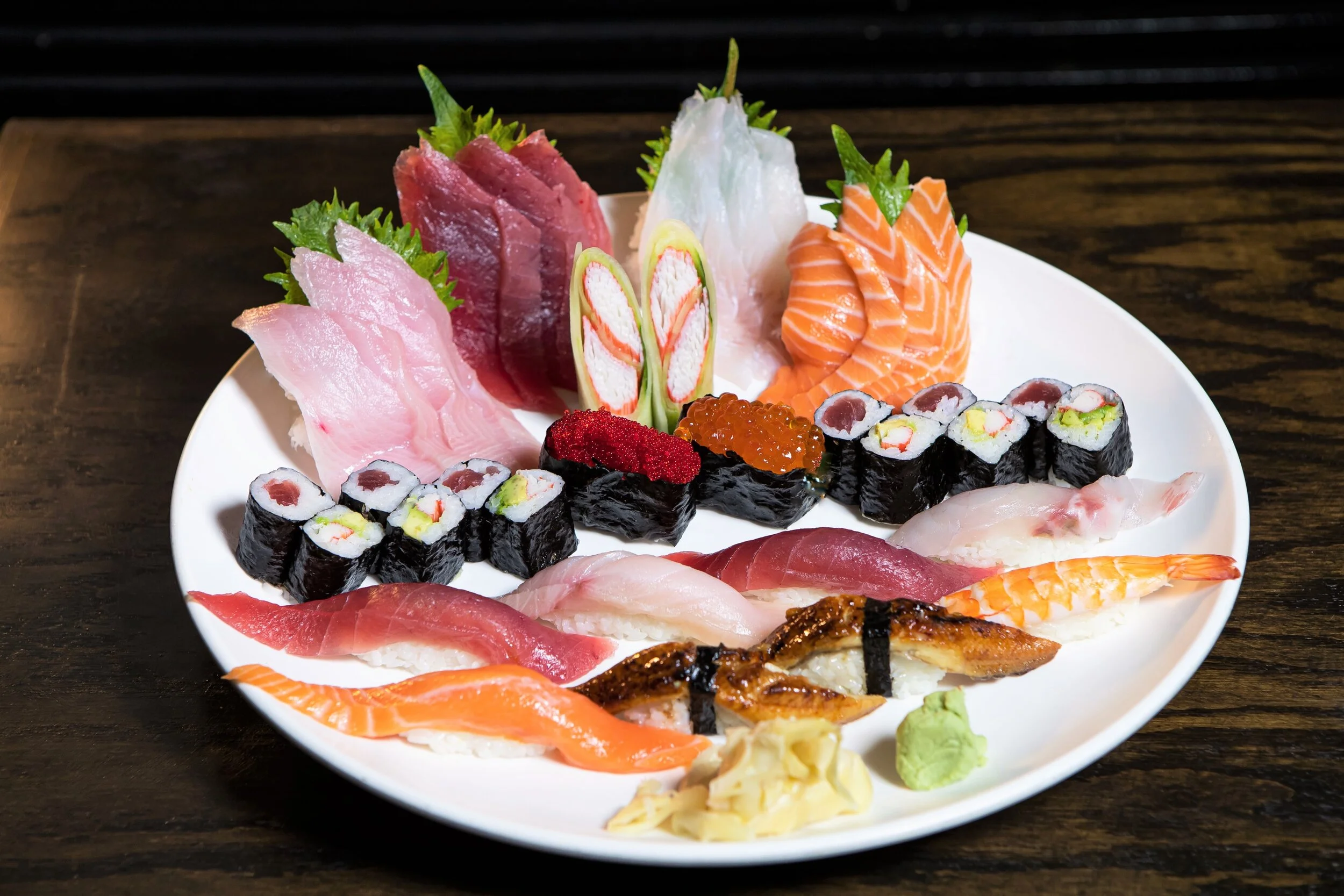 Sushi and sashimi combination plate on a white round plate