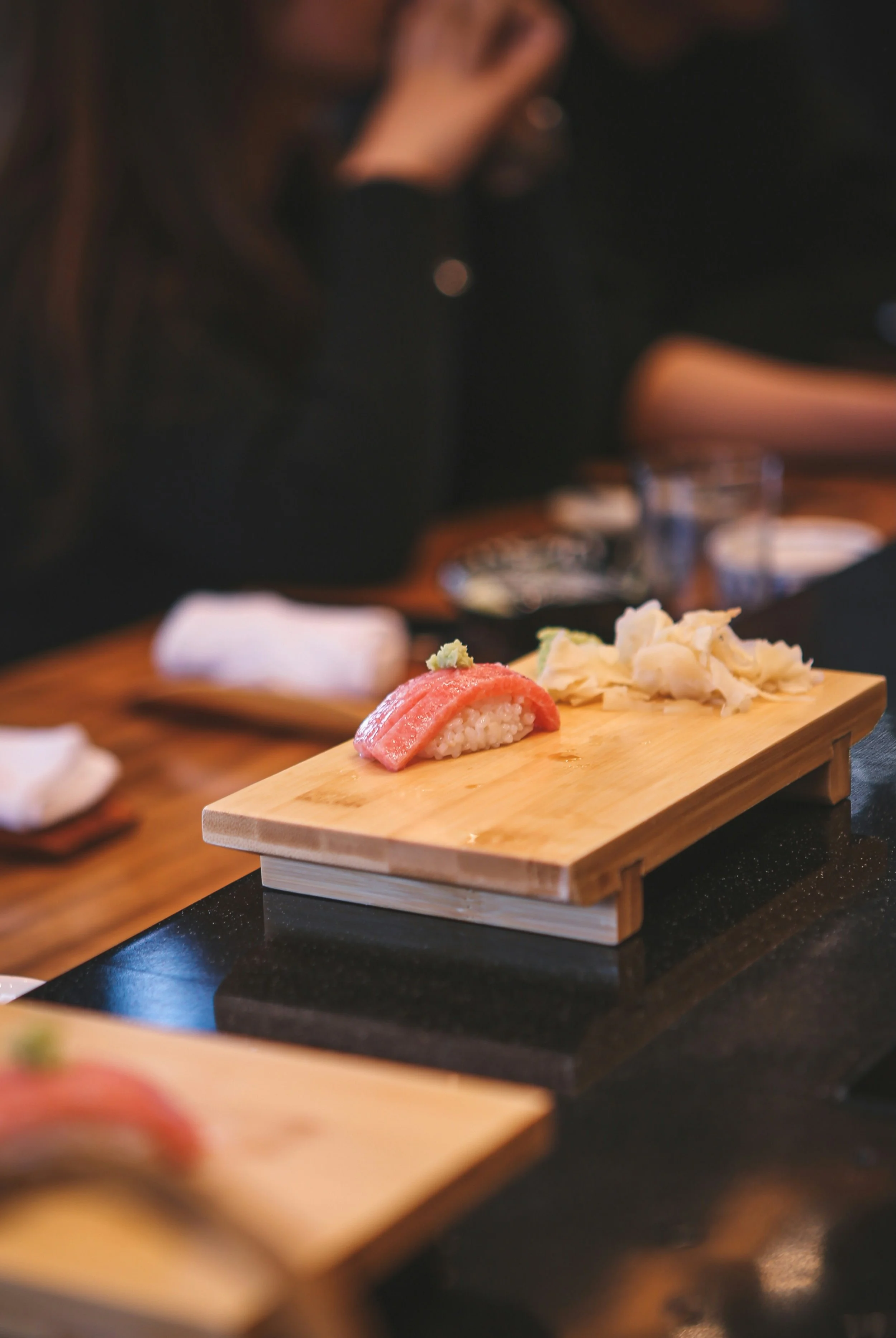 A single piece of nigiri on a wooden board