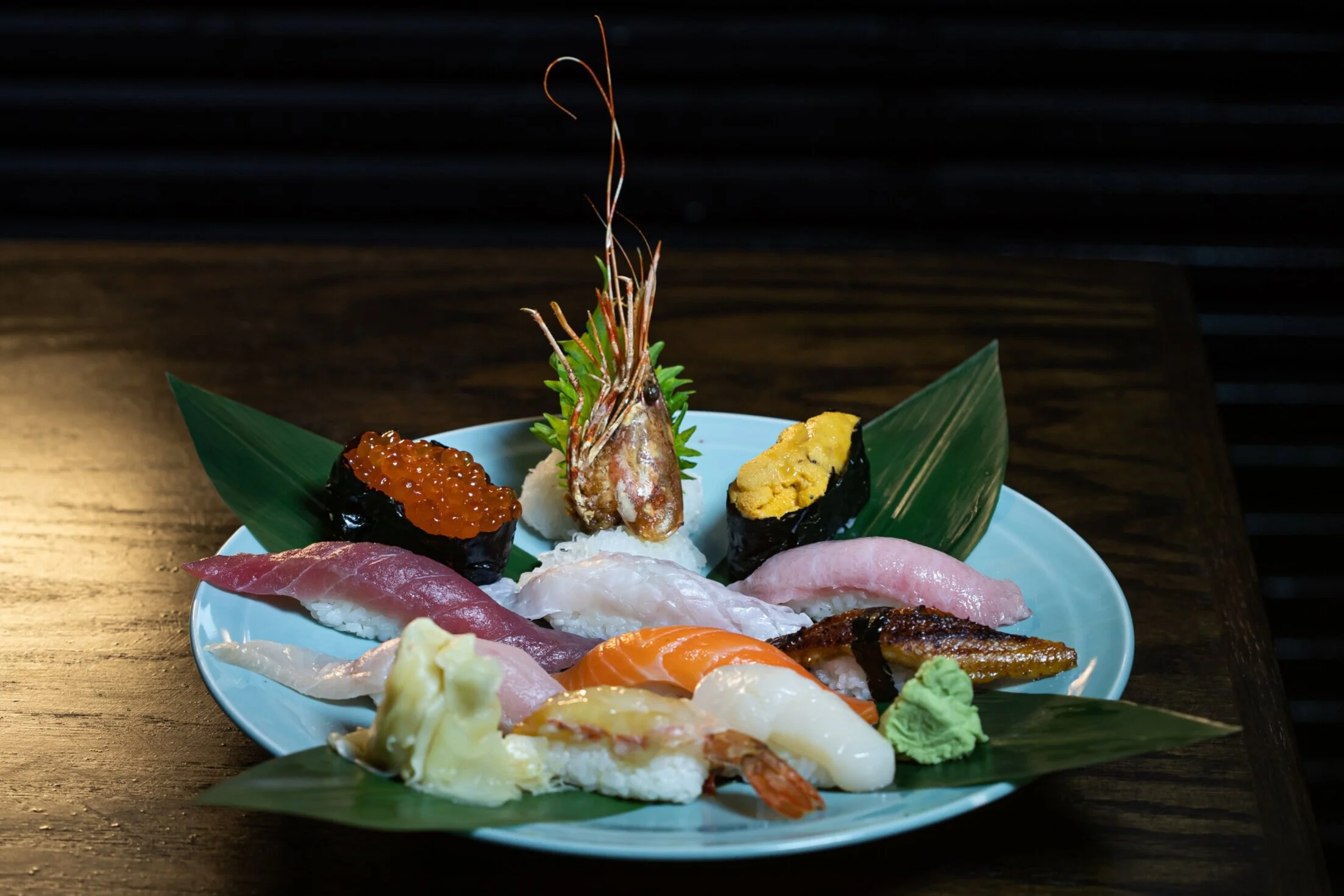 Nigiri assortment on a blue plate with uni and ikura