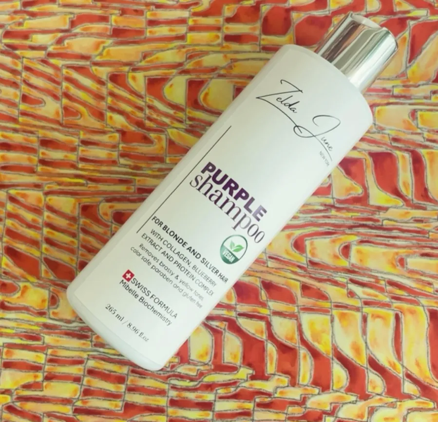 Zelda June branded Purple Shampoo bottle on a patterned surface
