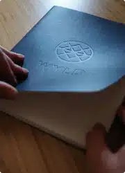 Leather-bound journal embossed with the WYLD compass logo on a wooden surface