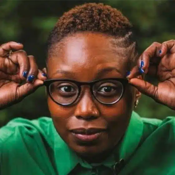 Shantae J. Edwards with short natural hair, round glasses and a green shirt