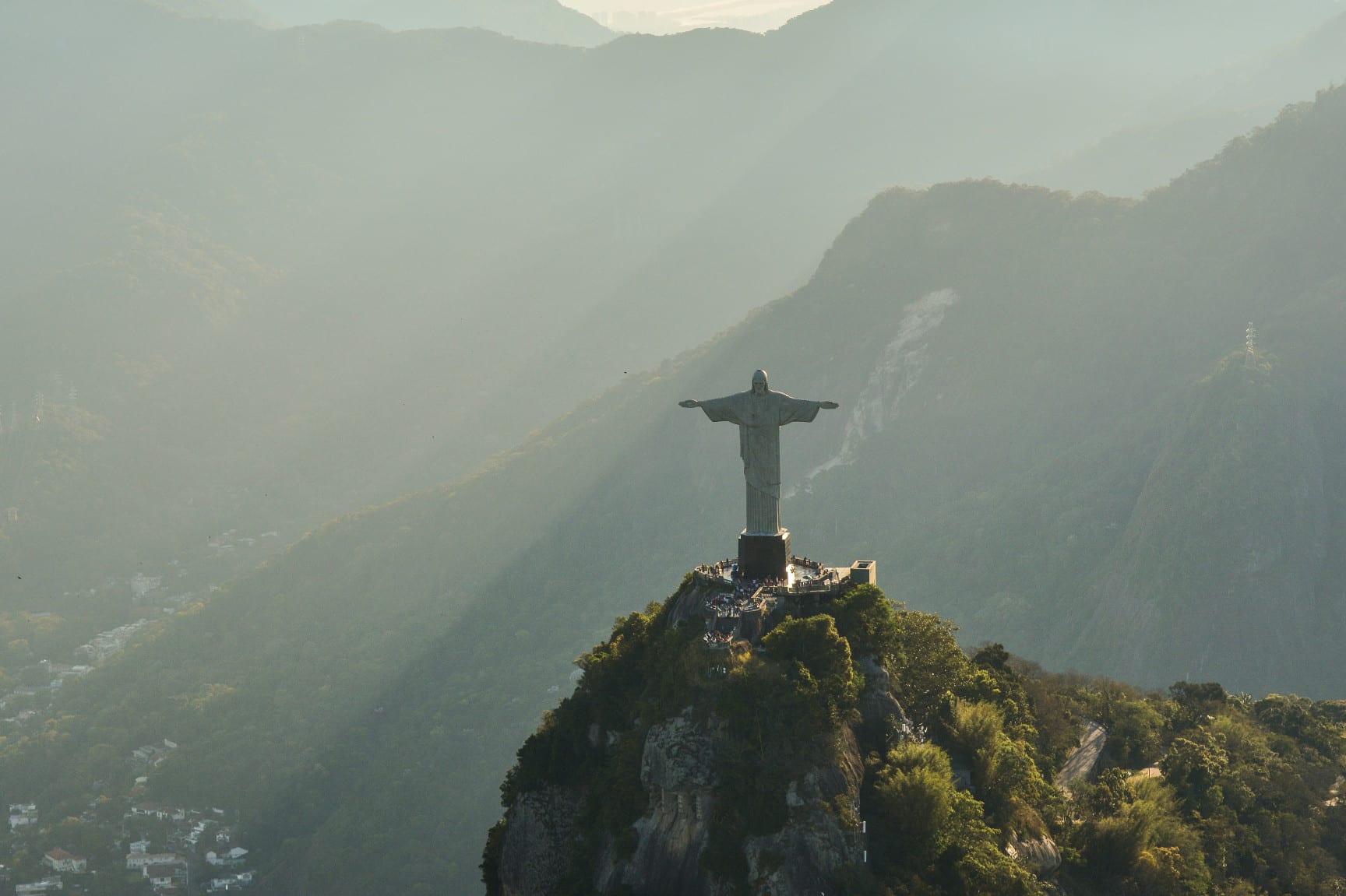 Aerial view of Christ the Redeemer statue on Corcovado mountain in misty green hills, Rio de Janeiro