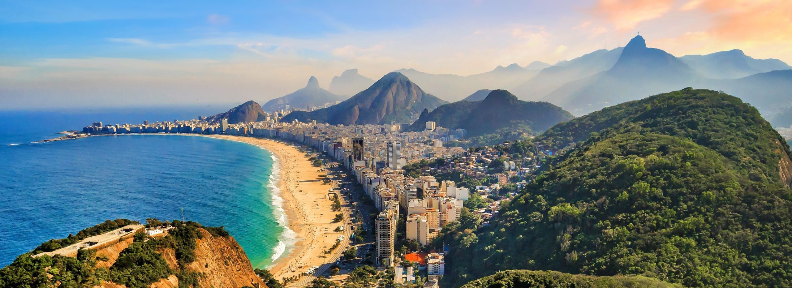 Aerial panoramic view of Copacabana Beach and Rio de Janeiro cityscape at sunset